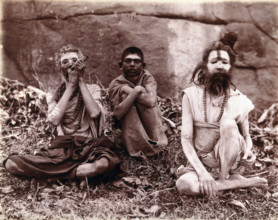 Two men and a boy sitting cross-legged on the ground surrounded by leaves; their faces...  1896/1897 Creator: Unknown.