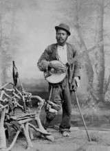 A black banjo player with a wooden leg, c1865. Creator: Unknown.
