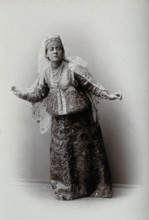 A woman posing in a photographic studio, wearing an embriodered dress, c1900s. Creator: Unknown.