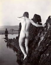 A man posing naked, with his back to the camera, standing on a rocky outcrop, c1900. Creator: Unknown.