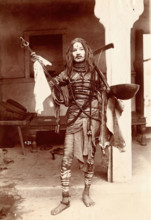 A young Indian man wearing many beads and makeup in a temple precinct, c1900. Creator: Unknown.
