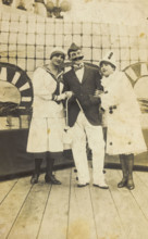 Three sailors, two in drag wearing pierrette costumes, pose on deck, c1910s. Creator: Unknown.