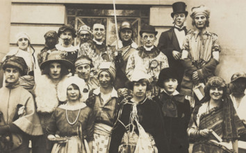 People gathered outside a building wearing various costumes, some in drag, 1924. Creator: Unknown.