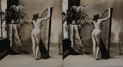 A young woman posing naked in a photographic studio, standing with her back to the camera..., c1900. Creator: Unknown.