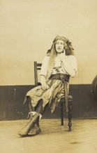A man in drag sits pensively on a chair, on the deck of a ship, (between 1910 and 1919?). Creator: Unknown.
