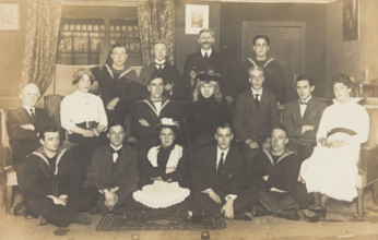 Sailors, some in drag, posing for a group portrait within a highly...(between 1910 and 1919?). Creator: Unknown.