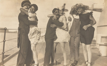 Sailors, some in drag, pose as three couples on the deck of a ship, (between 1920 and 1929?). Creator: Unknown.