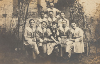 Concert party performers, one in drag, pose for a group portrait, (between 1910 and 1919?). Creator: Unknown.