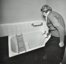 16 Candy Street, Poplar, London: elderly woman in bathroom, 1962. Creator: Unknown.