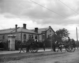 Street scene with horse carriages - possibly Ireland, 1898. Creator: Robert Augustus Henry L'Estrange.