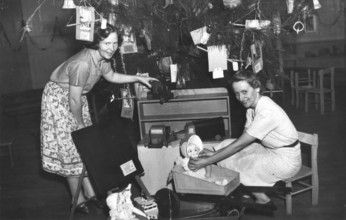 Brisbane Kindergarten Teachers College students/staff with presents and the Christmas tree, 1955. Creator: Unknown.