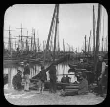 Men and boys with sailing boats in port, unknown location, c1900s. Creator: Robert Augustus Henry L'Estrange.