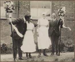 Two men holding tutti poles, with two women during the Hocktide Festival in Hungerford, 1925-35.  Creator: George R Long.
