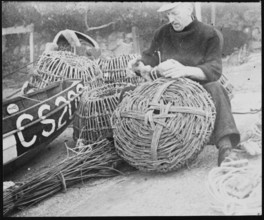 A fisherman making lobster pots at Steephill Cove, Ventnor, Isle Of Wight, 1930-1950. Creator: George R Long.