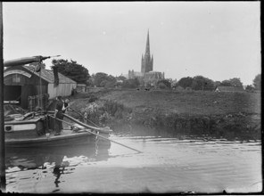 Norwich Cathedral from Pull's Ferry, with men on a boat in the foreground, Norwich, Norfolk, 1920-38 Creator: George R Long.