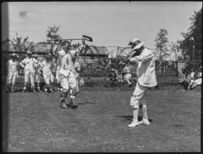 Bampton Morris troupe performing with a fiddler and someone holding a broom aloft, Oxon, 1920-30. Creator: George R Long.