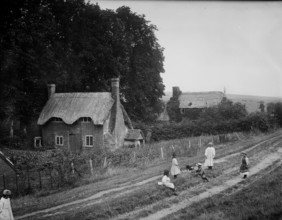 Some children playing with a dog on a rutted track, West Ilsley, West Berkshire, 1900. Creator: Henry Taunt.