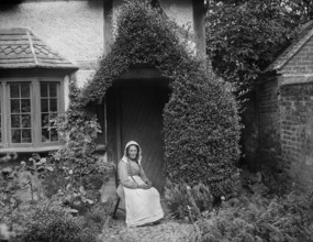 Portrait of an unknown elderly woman sitting outside her cottage, West Ilsley, West Berkshire, 1900. Creator: Henry Taunt.