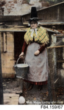 'Welsh woman looking after Piggy', Welsh costume postcard - woman carrying bucket, c1900s. Creator: Unknown.