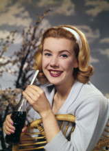 A young woman drinking a bottle of Coca-Cola, c1955.  Creator: Arthur Charles Kirby Ware.