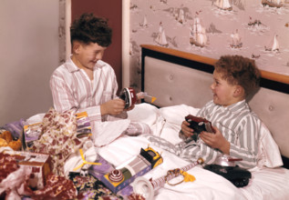 Two boys opening presents at Christmas, c1955-1965. Creator: Arthur Charles Kirby Ware.