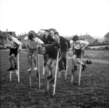 Children walking on stilts, c1955. Creator: Arthur Charles Kirby Ware.