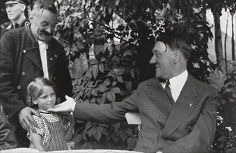 Hitler, on holiday in Obersalzberg, greeted by a local family, c.1935