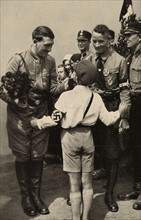 Hitler est salué par un jeune garçon lors de sa campagne électorale