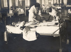 Dans un hôpital militaire à l'arrière du front, un médecin avec l'aide d'une infirmière, donnent