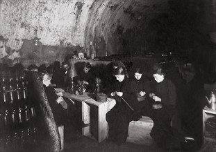 Une famille dans la cave d'une maison de vin de Champagne, à Reims, les femmes tricotent pour les