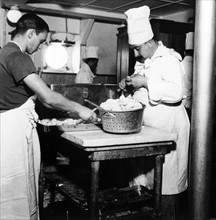 Le 19 août 1939, des cuisiniers s'affairent dans une partie  des cuisines du paquebot français