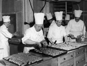 En juillet 1949, à bord du paquebot de luxe L'ILE DE FRANCE, des pâtissiers s'affairent à la tâche