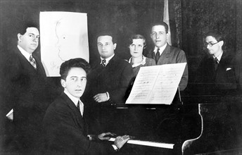 De gauche à droite : Darius Milhaud, Georges Auric (dessin sur le mur), Jean Cocteau, Arthur