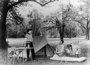 En 1955, un couple campe au milieu d'un champ. Ils disposent de tous les objets qui caractérisent
