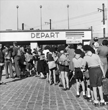 En août 1946, à la gare Montparnasse à Paris, un groupe d'enfants partant en colonie de vacances