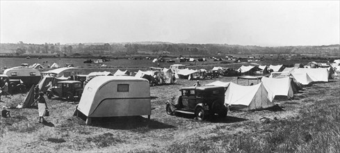 En août 1938, dans l'Orne, les caravanes, tentes et automobiles s'installent sur un terrain de