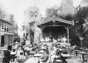 Vers 1880, à Paris, consommateurs assis dans le jardin intérieur du Moulin-Rouge, transformé en