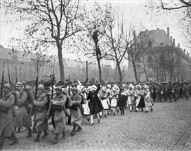 Défilé des troupes françaises à Metz auxquelles se mêlent des jeunes filles Lorraines enthousiastes
