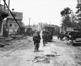 Troupes alliées traversant un village normand libéré après le débarquement du 6 juin 1944