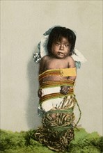Postcard representing a tied Indian child 
1902