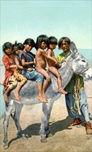 Postcard representing Hopi children on a donkey