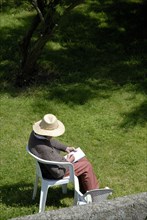 Personne âgée dessinant dans un jardin, 2007