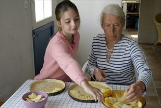 Girl making pastry with her grandmother