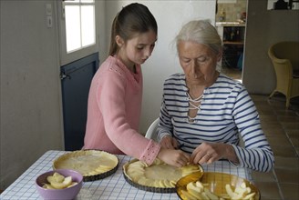 Girl making pastry with her grandmother