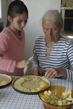 Girl making pastry with her grandmother