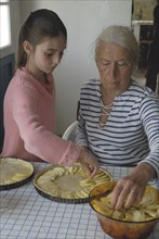 Girl making pastry with her grandmother