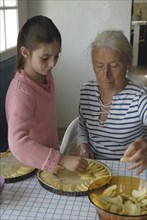 Girl making pastry with her grandmother