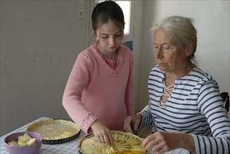 Girl making pastry with her grandmother