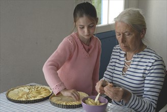 Girl making pastry with her grandmother