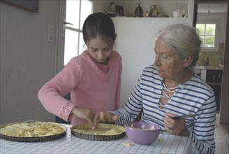 Girl making pastry with her grandmother